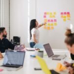 woman placing sticky notes on wall